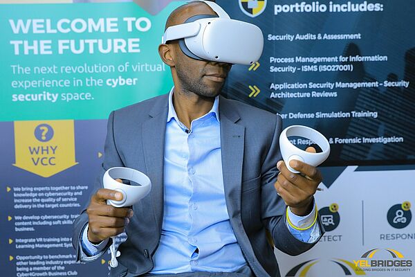 Mann mit Virtual Reality Brille auf einem Messestand, Text im Hintergund: Welcome to the future